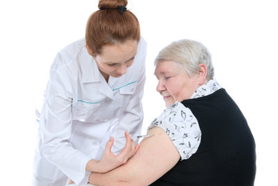 a doctor performing an injection to the elderly woman